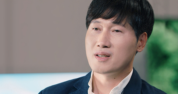 Lee Tae-rim, the managing director in a suit, is looking straight ahead and explaining OLED's personalization algorithm.